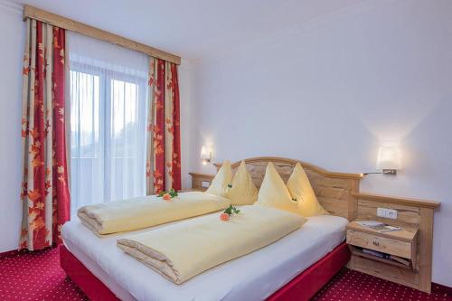 a bedroom with two beds and a large window at Hotel - Pension Ötzmooshof in Sankt Johann im Pongau