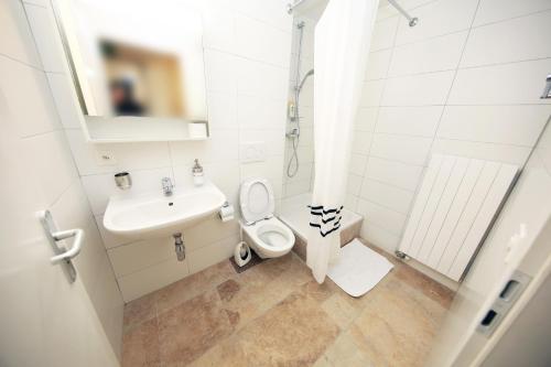 un bagno bianco con lavandino e WC di Cozy Apartment close to Cornavin Train Station and lake a Ginevra