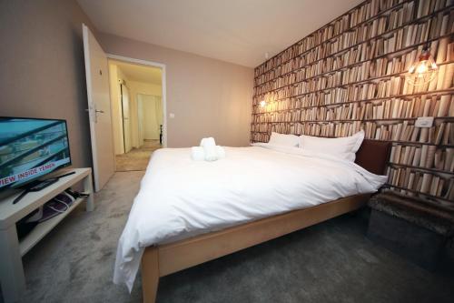 a bedroom with a large white bed and a tv at Cozy Apartment close to Cornavin Train Station and lake in Geneva