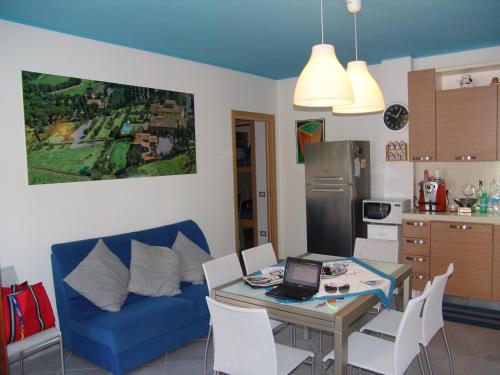 une cuisine avec un canapé bleu et une table avec un ordinateur portable dans l'établissement Blue apartment, à Marina di Castagneto Carducci