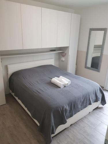 un letto con armadi bianchi e due asciugamani di Hotel Riviera Sanremo a Sanremo