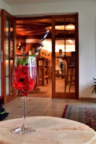 a drink in a wine glass on a table at Hotel Tradizio in Mittelberg