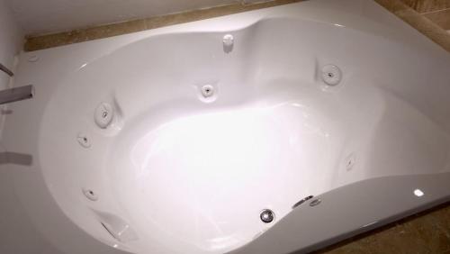 a white bath tub sitting on top of a floor at Hotel Rincon Real Suites in Durango