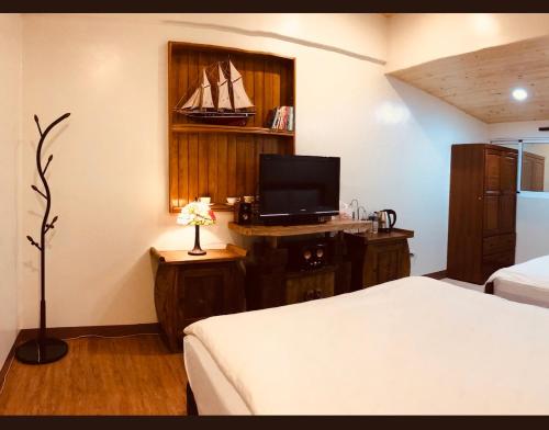 a bedroom with a bed and a tv on a desk at Grace House Homestay 2 in Majia