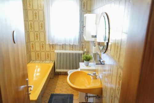 y baño con lavabo amarillo y bañera. en Ferienwohnung Heimberger, en Purgstall