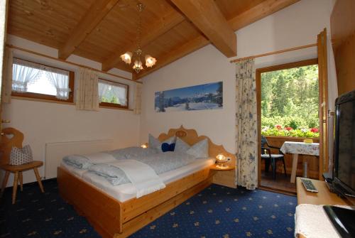 a bedroom with a bed and a tv and a table at Haus Tasser in Mayrhofen