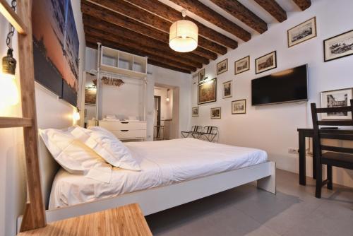 1 Schlafzimmer mit einem weißen Bett und einem TV in der Unterkunft Sottopiano - comfort in the center in Venedig