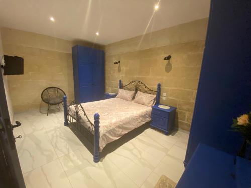 una camera con un letto e una sedia di Cosy private townhouse in heart of Senglea a Senglea