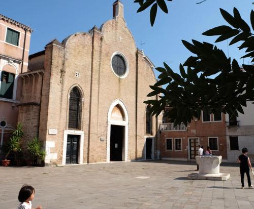 une grande église en briques avec un enfant debout devant elle dans l'établissement Al Piano - home away from home, à Venise