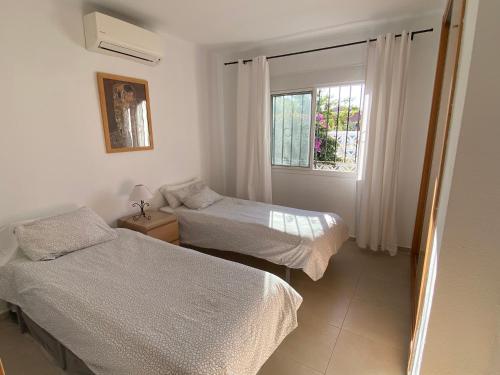 a bedroom with two beds and a window at Los Alamos in Torremolinos