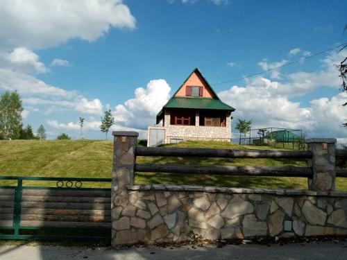 a house on a hill behind a fence at Orange House in nature in Žabljak