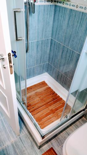 a shower with a wooden platform in a bathroom at Oriñon Beach Apartment in Oriñón