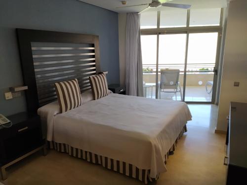 una camera da letto con un grande letto con due sedie di Anfi del Mar Tauro Golf 2 Emerald Club a Mogán