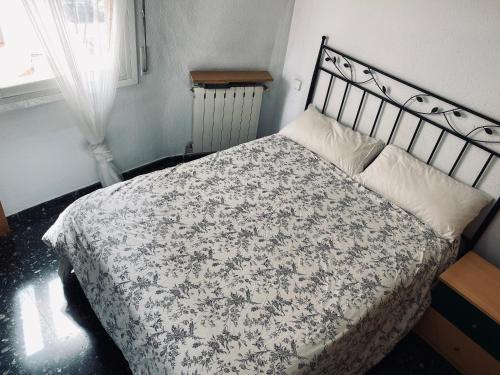 - une chambre avec un lit et une couverture noire et blanche dans l'établissement Habitaciones dakar, à Rubí