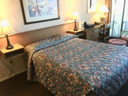 a hotel room with a bed and two lamps at Wessex Inn By The Sea in Cowichan Bay