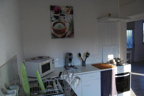 a kitchen with a dishwasher and a counter top at Gîte à la ferme avec piscine in Bernadets-Debat