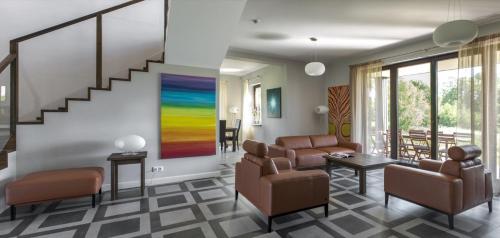 a living room with chairs and a painting on the wall at Hotel SPA Dr Irena Eris Wzgórza Dylewskie - Siedliska in Wysoka Wieś