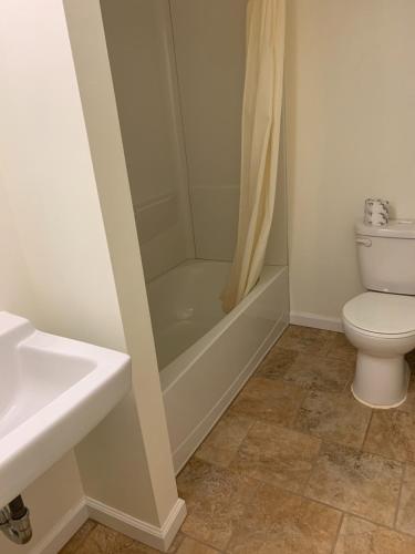 a bathroom with a toilet and a shower and a sink at Express Inn in Lakehurst