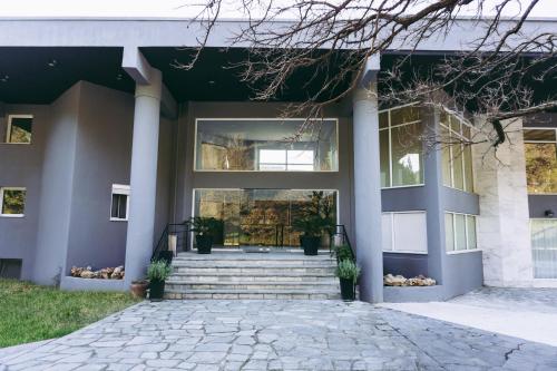 una casa con porche delantero y escaleras en Pravi Hotel, en Eleftheroúpolis
