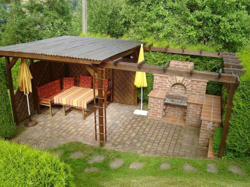 einen Pavillon mit einem Tisch, Stühlen und einem Kamin in der Unterkunft Ferienwohnung Goldene Höhe in Rechenberg-Bienenmühle