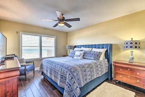 een slaapkamer met een blauw bed en een plafondventilator bij Luxe Oceanfront Condo with Pool Beach Access and Gear in Ormond Beach