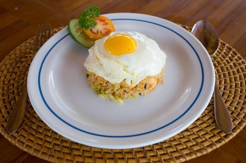 een bord voedsel met een ei op de rijst bij Rijet Villa Beach & Restaurant in Nusa Penida