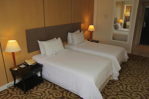 a hotel room with two beds and a telephone at Perdana Kota Bharu in Kota Bharu