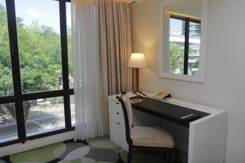 a desk with a telephone in a room with a window at Perdana Kota Bharu in Kota Bharu