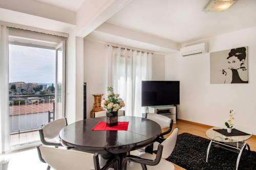 a living room with a table and chairs and a television at Rooms&Apartments Zelux in Split