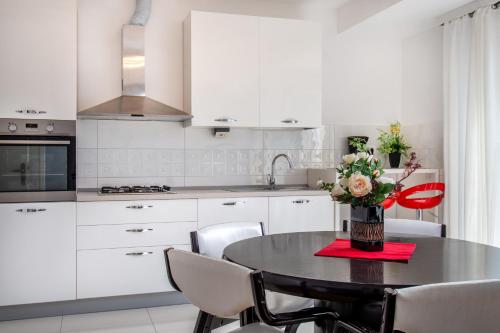 a kitchen with a table with a vase of flowers on it at Rooms&Apartments Zelux in Split