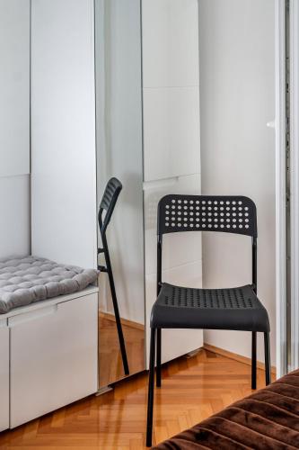 a black chair in a room next to a cabinet at Rooms&Apartments Zelux in Split