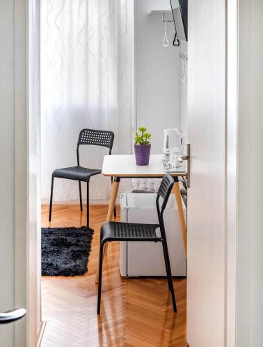 a dining room with a table and two chairs at Rooms&Apartments Zelux in Split