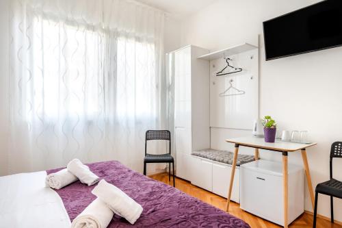 a bedroom with a bed and a table and chairs at Rooms&Apartments Zelux in Split