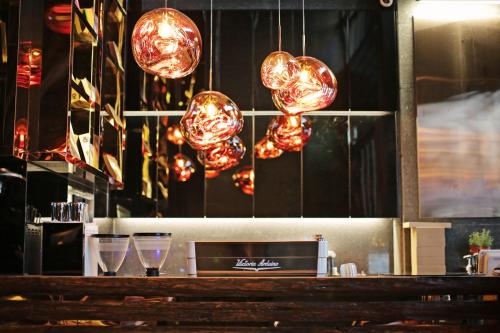 a bar with glasses and lights above a counter at Best Louis Hamilton Hotel Gwangan in Busan