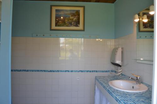 a bathroom with a sink and a phone at Village de gîtes Les Olivettes in Saint-Dézéry