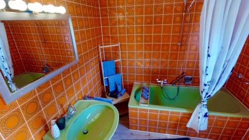 ein Badezimmer mit einem grünen Waschbecken und einer Badewanne in der Unterkunft Dani`s Ferienwohnung in Freiamt