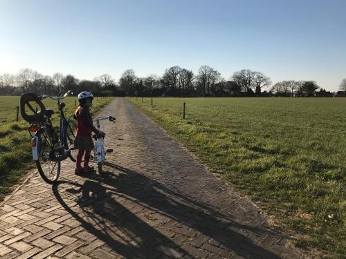 a young girl standing next to a bike on a dirt road at Appartement "in de wolken" in Gees in Gees