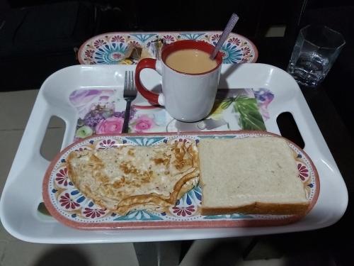 ein Tablett mit einem Teller Essen und einer Tasse Kaffee in der Unterkunft StayCation Suites And Apartment in Lagos