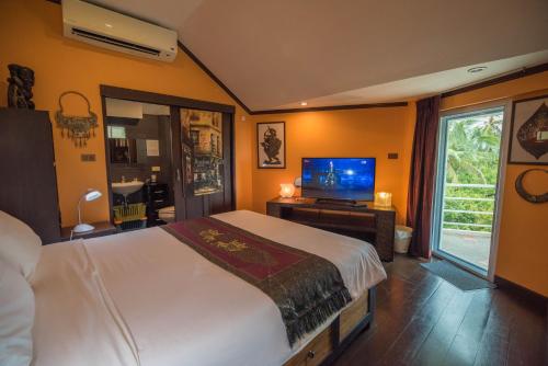 Un dormitorio con una cama y un televisor de pantalla plana. en Chaweng Noi Residence, en Chaweng Noi Beach