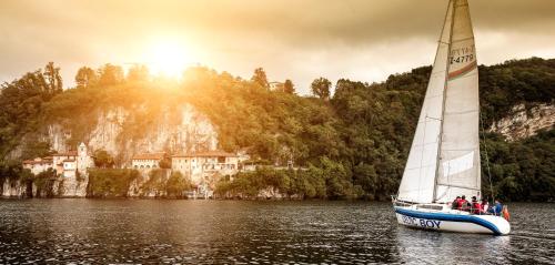 a sailboat on the water with a house in the background at Villa Lucciola in Stresa
