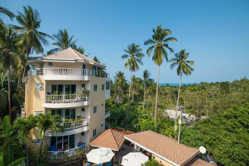 un edificio de apartamentos con palmeras en el fondo en Chaweng Noi Residence, en Chaweng Noi Beach