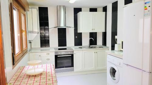 a white kitchen with black and white striped walls at La Casa de Begoña in Laguardia