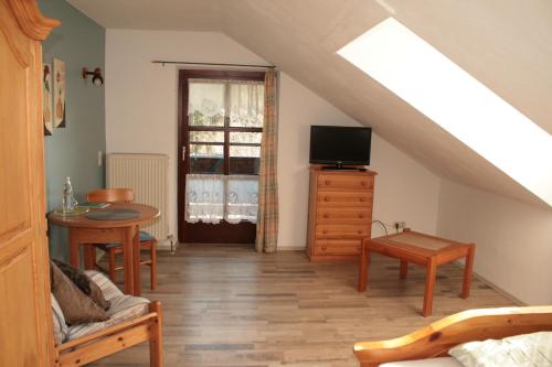Zimmer mit einer Treppe, einem TV und einem Tisch in der Unterkunft Waldpension Jägerstüberl in Bad Griesbach