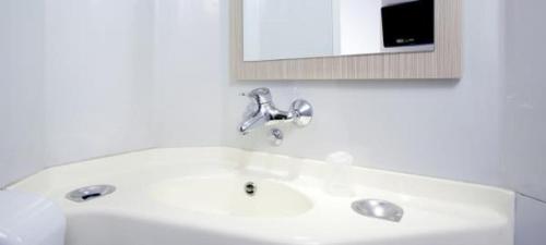 um lavatório branco na casa de banho com um espelho em Premiere Classe Charleville Mezieres em Charleville-Mézières
