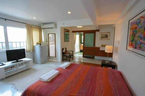 a large bedroom with a large bed and a television at Cha_Inn @ Cha Am in Cha Am