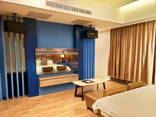 a room with a bedroom with a bed and a table at Discovery Motel - Nangang臺北市旅館349-2號 in Taipei