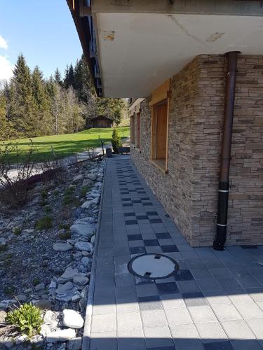 a walkway next to a brick building with a door at Chalet Grüneggli in Adelboden