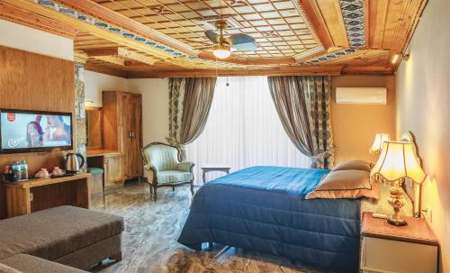 una habitación de hotel con una cama y un televisor en Gumus Konak, en Akyaka
