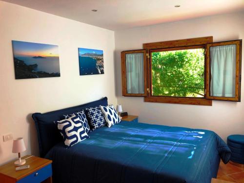 Un dormitorio con una cama azul y una ventana en Chalet Paradiso, en Sorrento