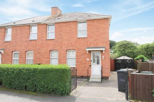 a brick house with a white door and a fence at Beautiful Home Near Worcester Royal Hospital in Hindlip